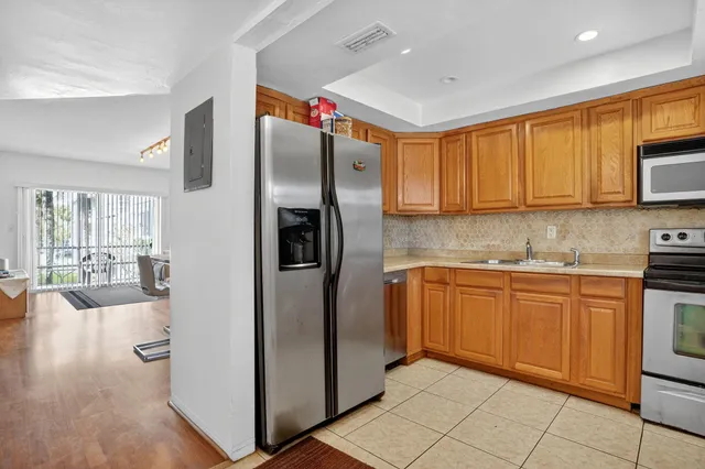 a kitchen with stainless steel appliances granite countertop a refrigerator a sink and a microwave