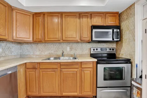 a kitchen with granite countertop a stove sink and cabinets