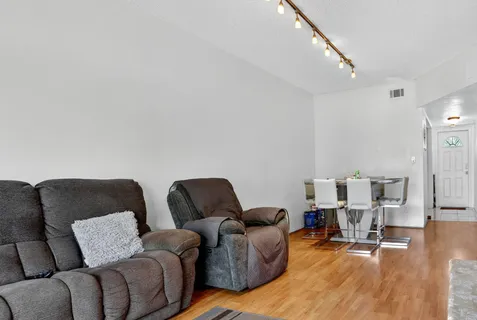 a living room with furniture and wooden floor