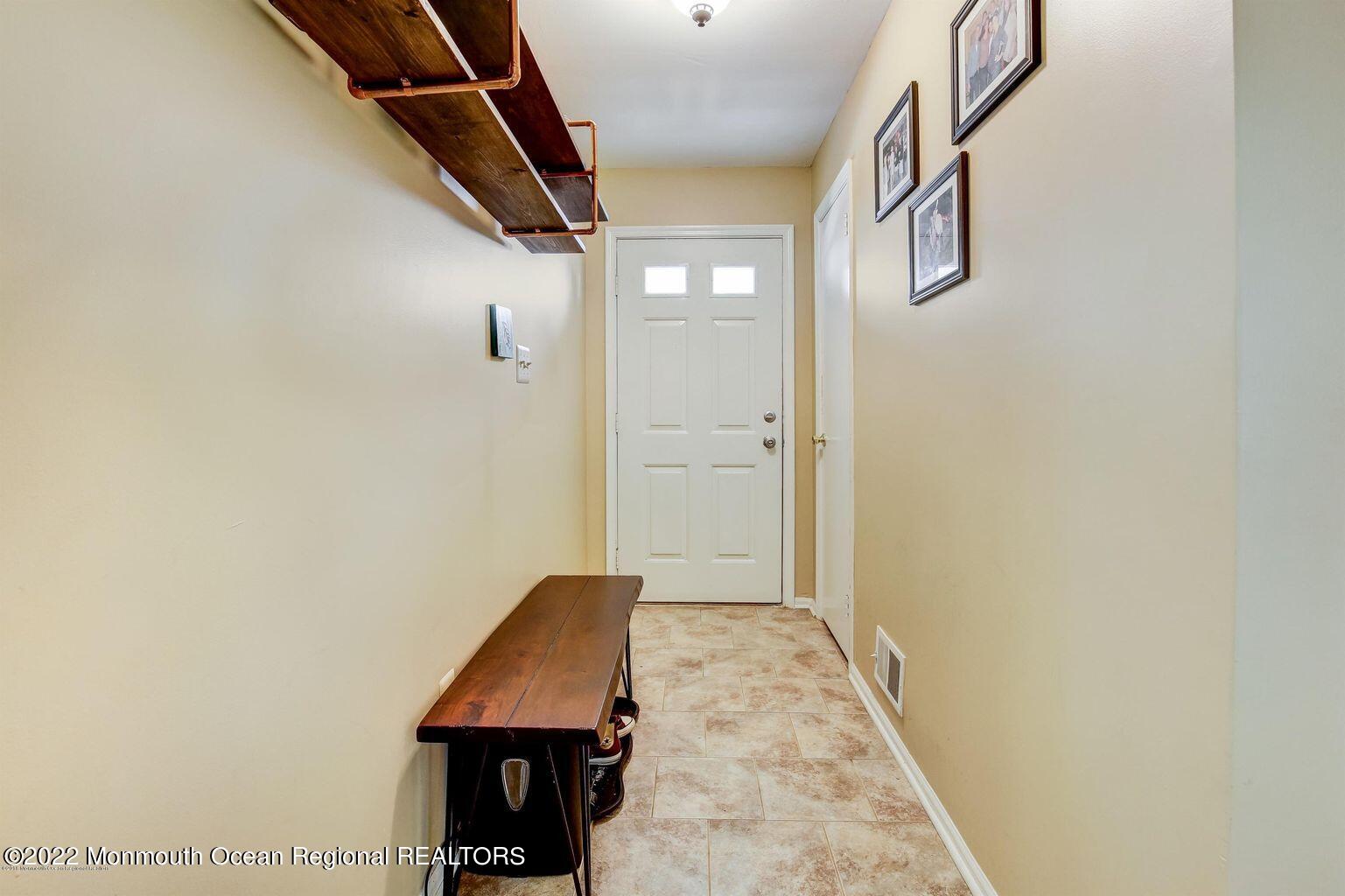 123 Hyacinth Lane Freehold, NJ 07728 - Photo 3 of 28 a view of a hallway with wooden floor and a bathroom