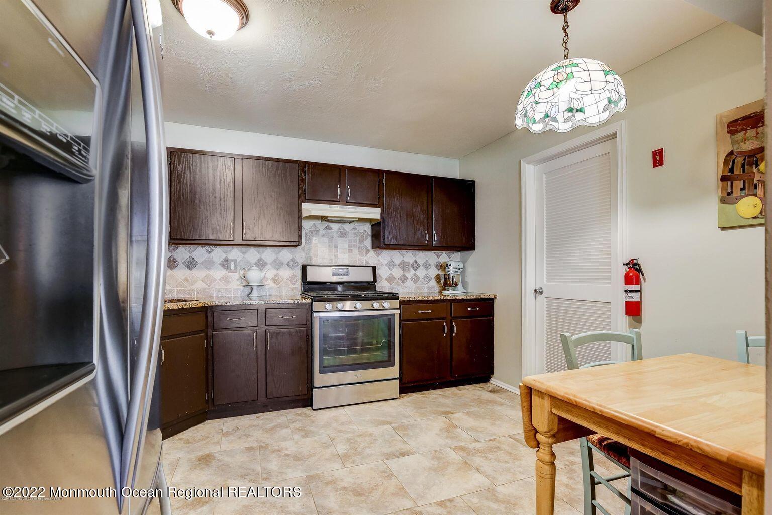 123 Hyacinth Lane Freehold, NJ 07728 - Photo 8 of 28 a kitchen with kitchen island stainless steel appliances a stove refrigerator sink and microwave