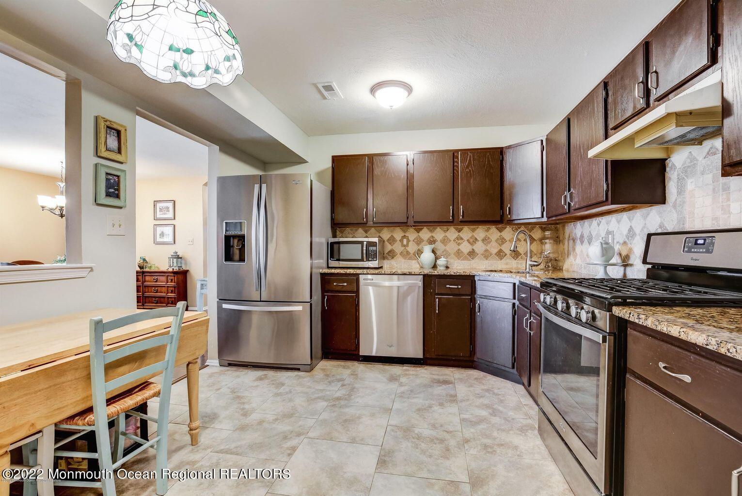 123 Hyacinth Lane Freehold, NJ 07728 - Photo 10 of 28 a kitchen with stainless steel appliances granite countertop a stove refrigerator and a sink