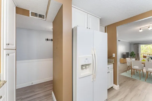 a view of a livingroom with wooden floor and a bathroom