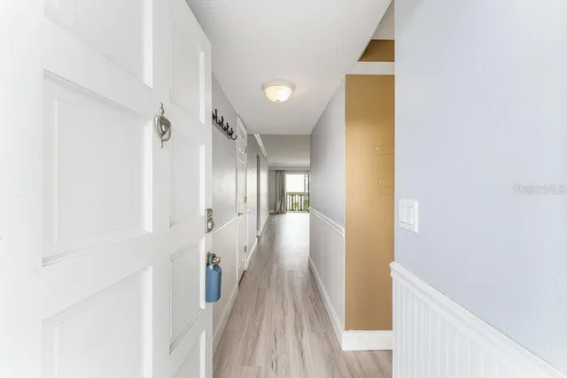 a view of a hallway with wooden floor