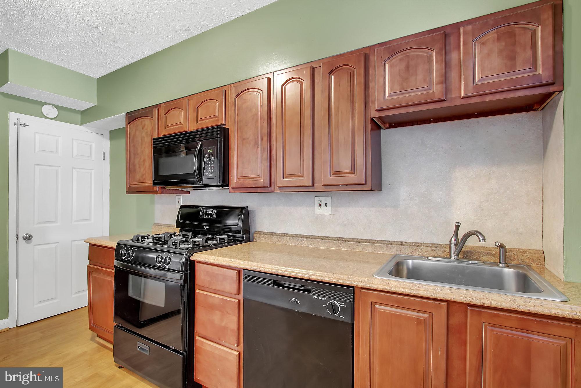 7817 Lockwood Road Baltimore, MD 21222 - Photo 3 of 23 a kitchen with stainless steel appliances granite countertop a sink stove and microwave