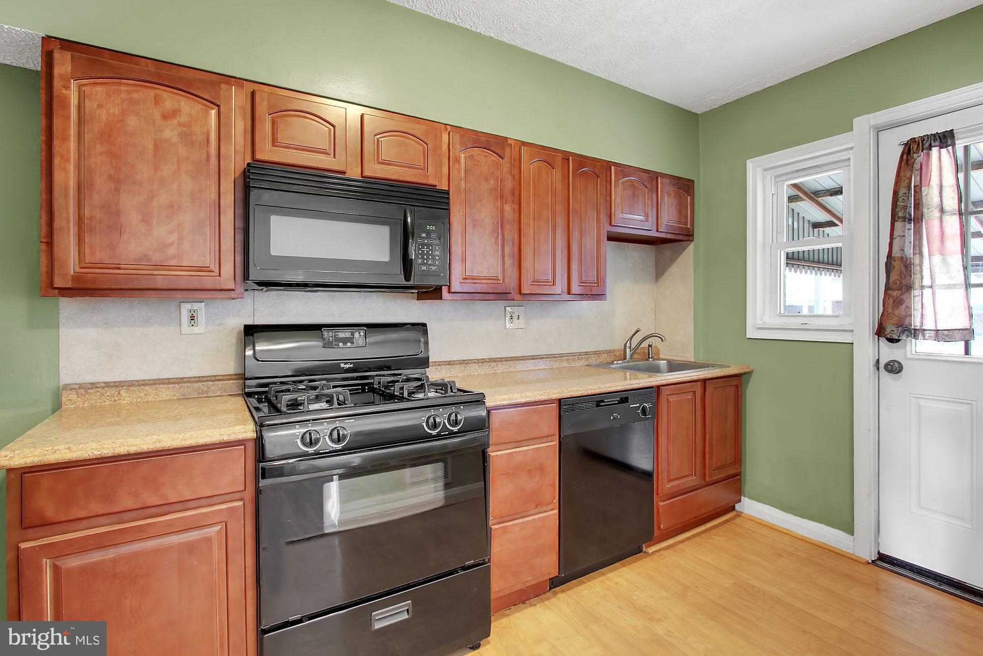 7817 Lockwood Road Baltimore, MD 21222 - Photo 9 of 23 a kitchen with granite countertop cabinets stainless steel appliances and a window