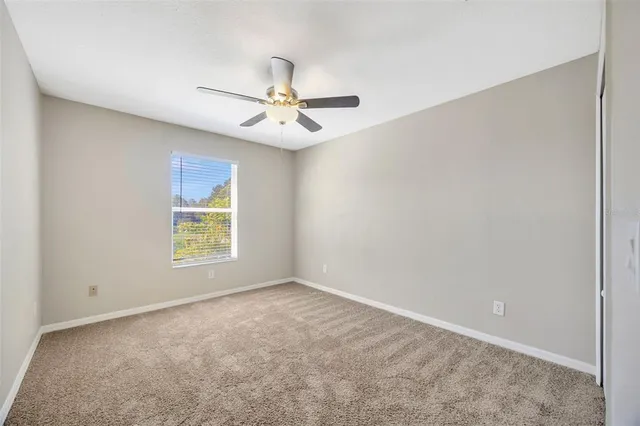 an empty room with a window and a fan
