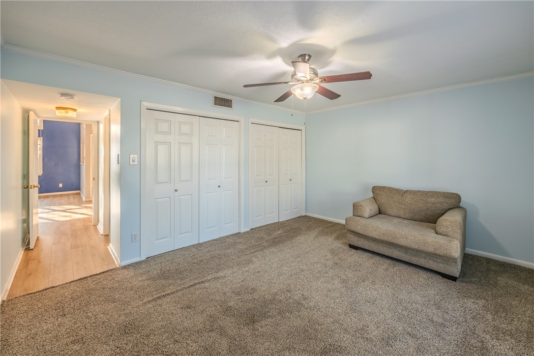 2002 South Lubbock Street Brenham, TX 77833 - Photo 18 of 26 Living area featuring crown molding, carpet flooring, and ceiling fan