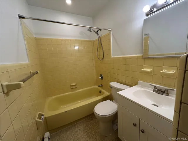 a bathroom with a sink mirror toilet and bathtub