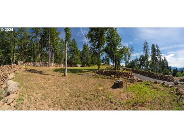 a view of a yard with wooden fence