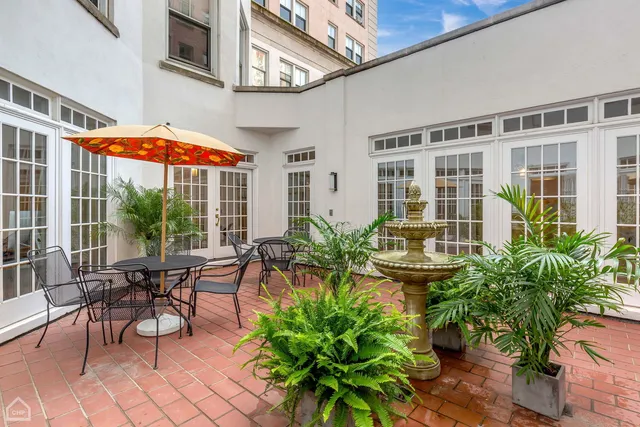 a view of a patio with table and chairs potted plants and floor to ceiling window and wooden floor