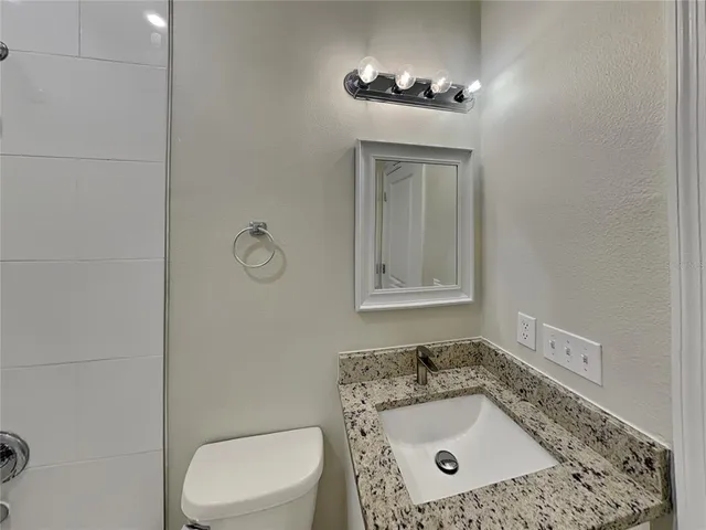 a bathroom with a sink a toilet and mirror