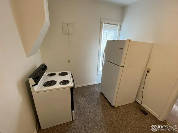 a white refrigerator freezer and a stove sitting inside of a kitchen