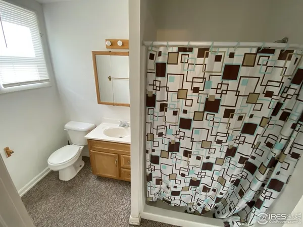 a bathroom with a toilet and a shower curtain