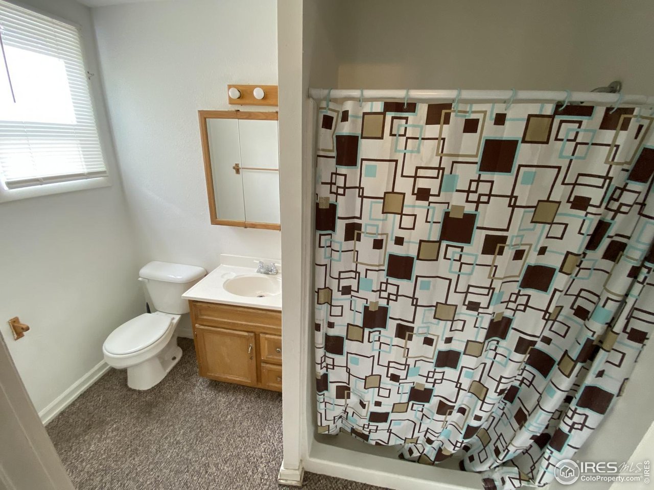 303 South 2nd Street Sterling, CO 80751 - Photo 4 of 37 a bathroom with a toilet and a shower curtain