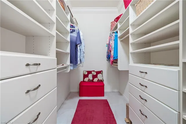 a view of walk in closet with clothes and shoes