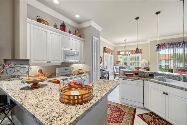 a kitchen with stainless steel appliances granite countertop a sink a stove and a wooden cabinets