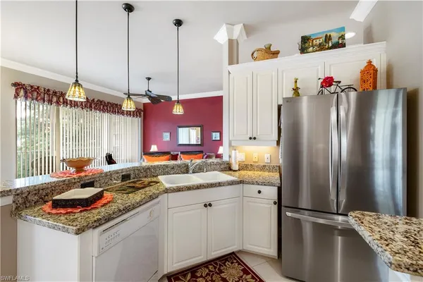a kitchen with stainless steel appliances granite countertop a refrigerator a sink and a stove