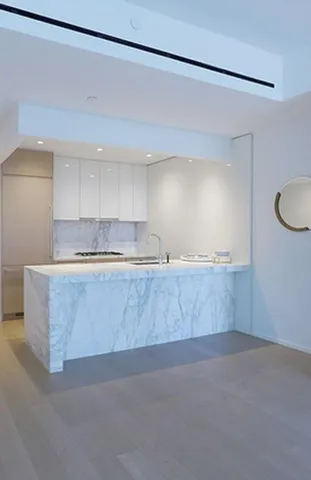 a kitchen with kitchen island a sink counter top space and cabinets