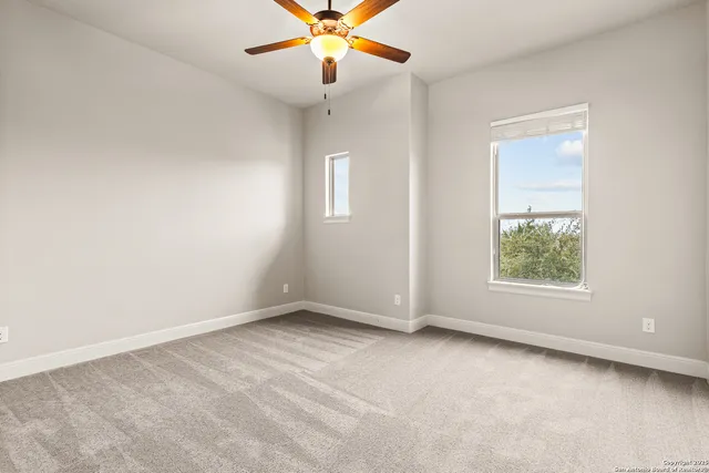 an empty room with a window and a fan