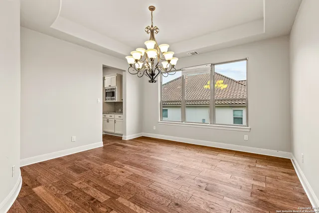 a view of a big room with wooden floor and chandelier