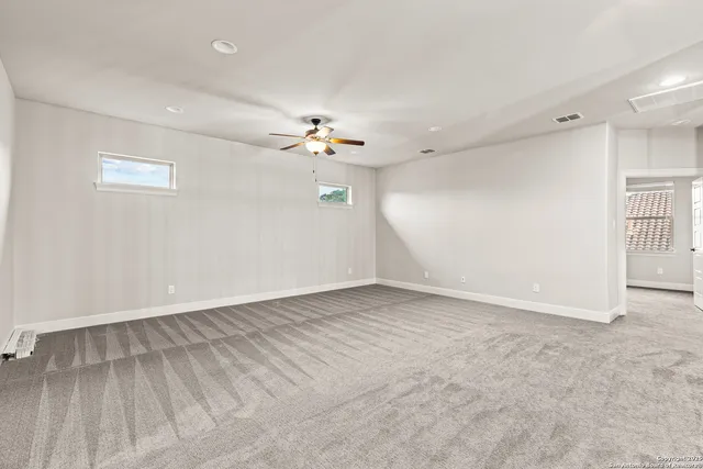 a view of an empty room with a chandelier fan