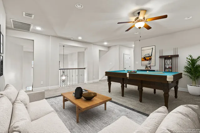 a living room with furniture a ceiling fan and a rug