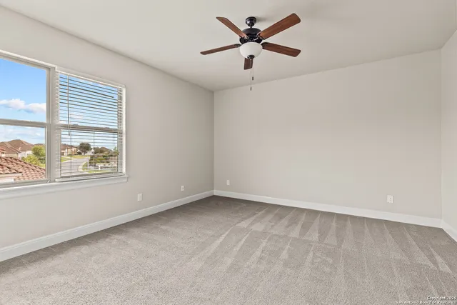 an empty room with a window and a fan