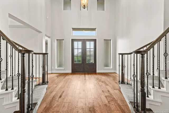 a view of a hallway with wooden floor and staircase