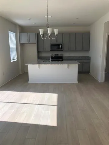 a view of kitchen with stainless steel appliances granite countertop stove top oven and cabinets
