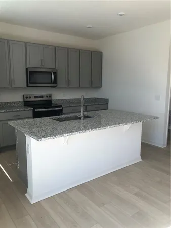 a kitchen with granite countertop a sink and a stove top oven