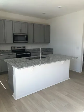 a kitchen with granite countertop a sink and a stove top oven