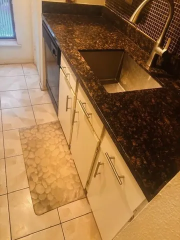a kitchen with a sink a stove and a wooden floor