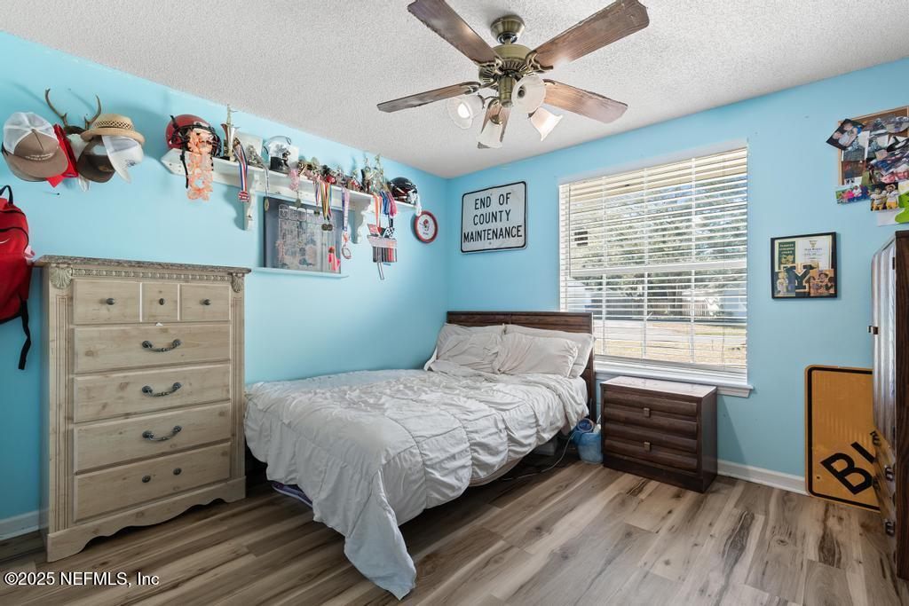 83096 St Mark Drive Yulee, FL 32097 - Photo 19 of 35 a bedroom with a bed dresser and wooden floor