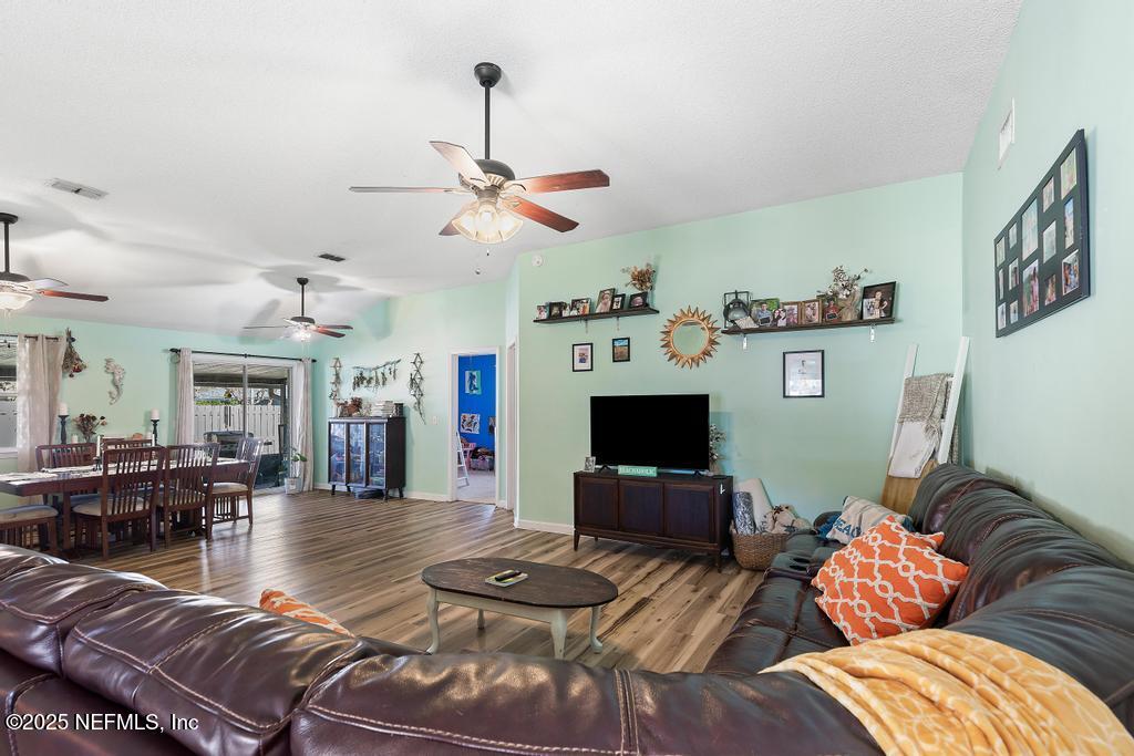 83096 St Mark Drive Yulee, FL 32097 - Photo 7 of 35 a living room with furniture a dining table and a fireplace