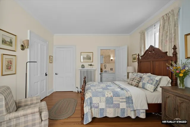 a view of a white house next to a yard with large trees