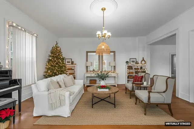 a living room with furniture a chandelier and a window