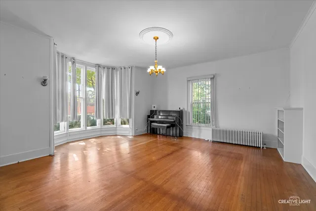 a view of a room with wooden floor fireplace and windows