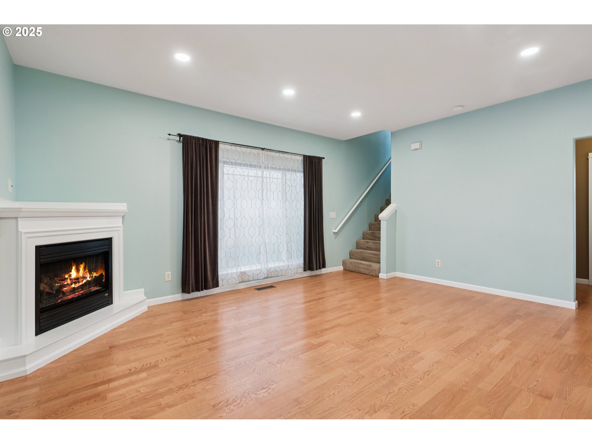 18232 Southwest Orlov Court Beaverton, OR 97078 - Photo 4 of 15 a view of an empty room with wooden floor fireplace and a window