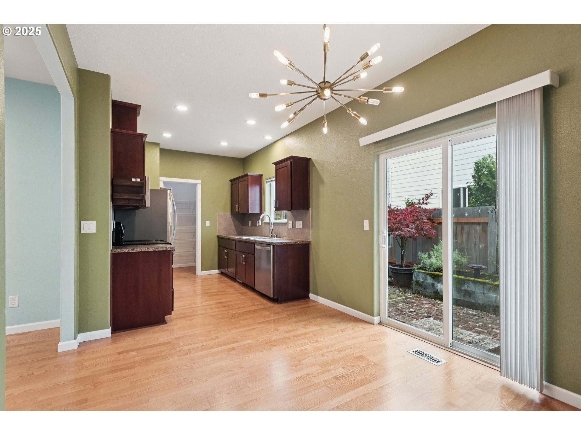 18232 Southwest Orlov Court Beaverton, OR 97078 - Photo 6 of 15 a kitchen with stainless steel appliances kitchen island granite countertop a refrigerator and a sink