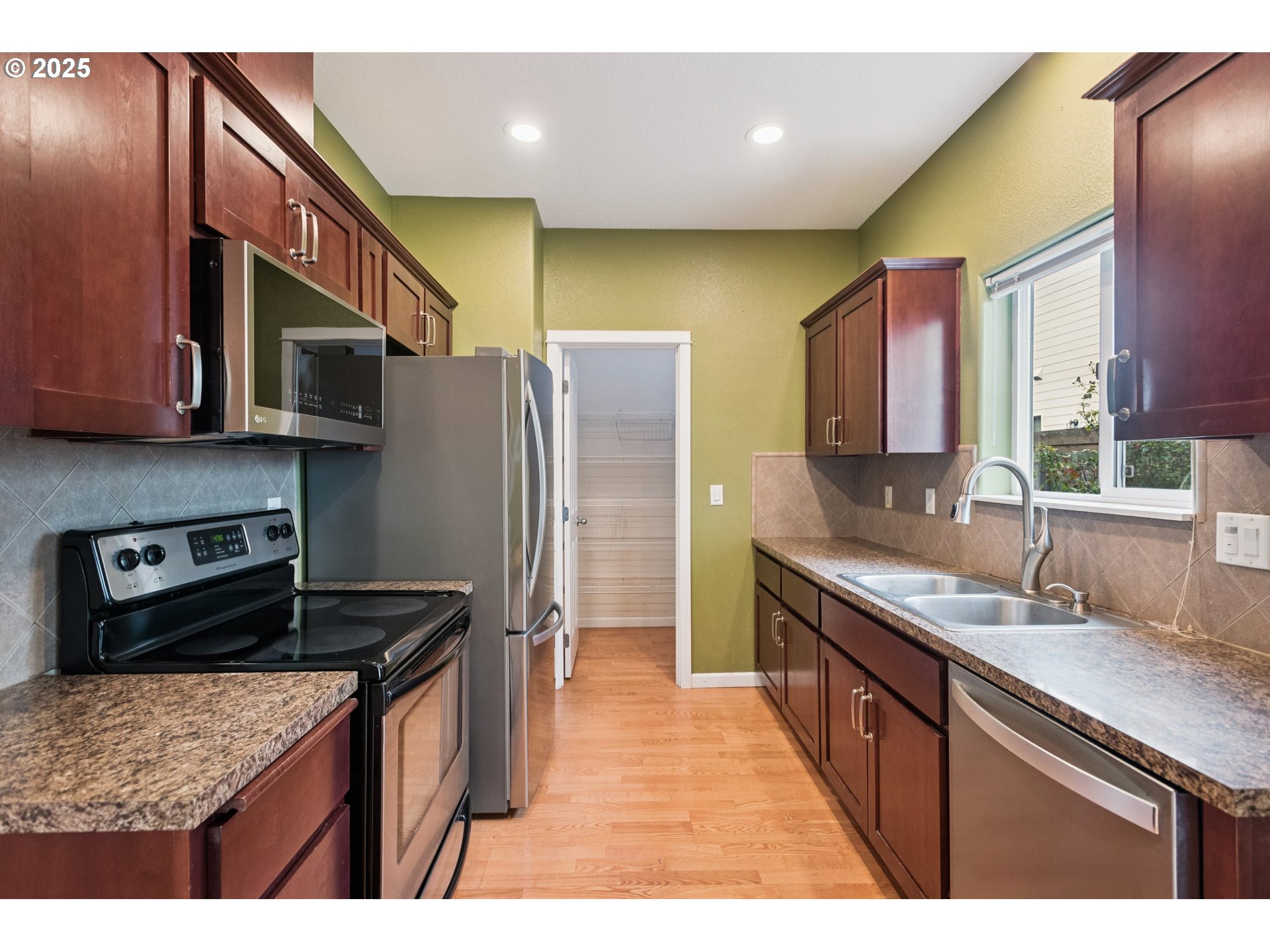 18232 Southwest Orlov Court Beaverton, OR 97078 - Photo 7 of 15 a kitchen with stainless steel appliances granite countertop a sink stove and refrigerator