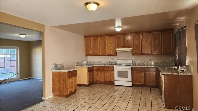 a kitchen with stainless steel appliances granite countertop a stove top oven a sink dishwasher and a refrigerator