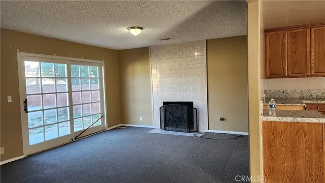 an empty room with windows and fireplace
