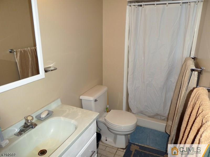 4 Lexington Road Somerset, NJ 08873 - Photo 12 of 14 a bathroom with a sink a toilet and shower curtain