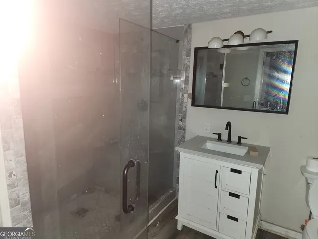a bathroom with a granite countertop sink vanity and mirror