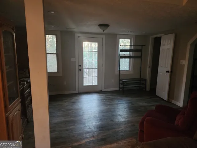 an empty room with wooden floor and windows