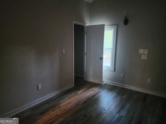 an empty room with wooden floor and closet