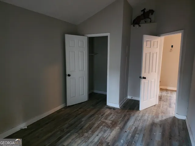 an empty room with wooden floor and a ceiling fan