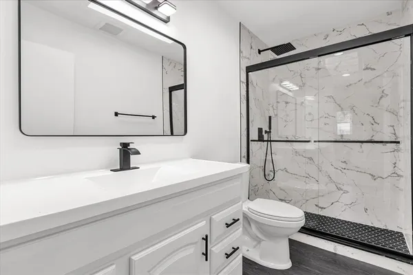 a bathroom with a sink a toilet and a mirror