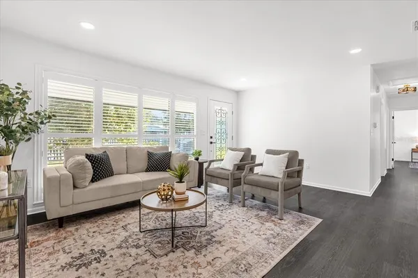 a living room with furniture wooden floor and a large window